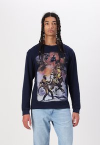 Navy long-sleeve t-shirt featuring a graphic print of characters and creatures from a sci-fi scene, with a crew neck and textured fabric.