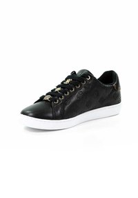 Baskets en cuir noir avec motifs embossés, charms décoratifs dorés sur les lacets, lacets noirs et semelle en caoutchouc blanche, positionnées en angle vers la gauche sur fond blanc.