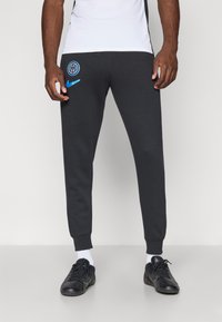 Black athletic joggers with tapered legs, featuring a blue Inter Milan logo and a blue Nike swoosh. Made from a soft, stretchy material.