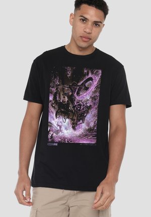 Junger Mann trägt ein schwarzes T-Shirt mit einem lila, schwarzen und weißen Marvel-Themen-Grafik, die eine dynamische Motorradszene zeigt.
