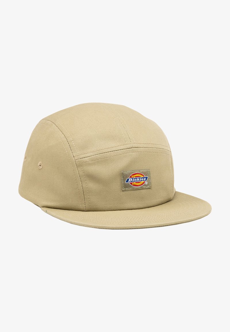 Beige lippalakki, joka on valmistettu kestävästä kankaasta, sisältää litteän lakanan ja edessä on "Dickies"-logo-epäonnistuminen. Ompeleet ovat näkyvissä.