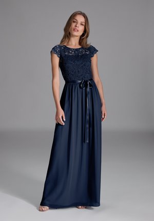 Abito da sera blu navy con corpetto in pizzo, maniche corte e gonna fluida. Presenta una cintura legata in vita e una texture morbida.