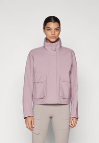 Light purple jacket with a high collar, two front flap pockets, and a streamlined design featuring minimal stitching and a smooth texture.