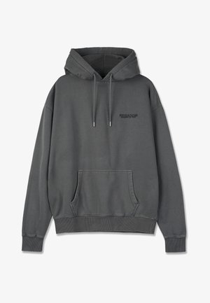 Siva kapuča iz bombaža. Ima sprednji žep, rebraste manšete in rob. Na prsih je natisnjena blagovna znamka.