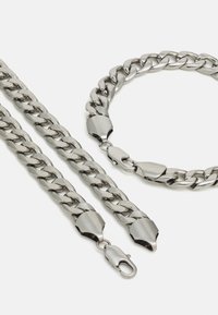 Sølvmetal kæde smykkesæt bestående af en halskæde og et armbånd, med sammenkoblede led og robuste lobster-krog låse.