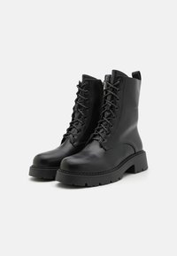 Botine negre din piele cu vârful rotund, închidere cu șireturi în față, fermoar pe lateral și talpă din cauciuc masiv cu margine texturată.