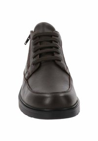 Bruine leren veterschoenen met een ronde teen, voorzien van contrasterende biezen, een gestructureerd oppervlak en een zijrits voor gemakkelijke toegang. Zwarte rubberen zool.