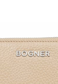 Portafoglio in pelle beige con una finitura testurizzata, caratterizzato dal logo argento "BOGNER" e una chiusura a zip lungo il bordo superiore.