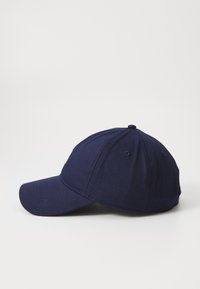 Sötétkék baseball sapka, strukturált koronával, ívelt napellenzővel és varrott részletekkel. Simább textúrájú szövetből készült.