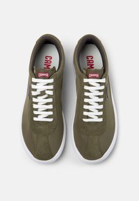 Green fabric sneakers with white laces, round toe, low profile, contrasting stitching, and a red "CAMPER" logo on the tongue.