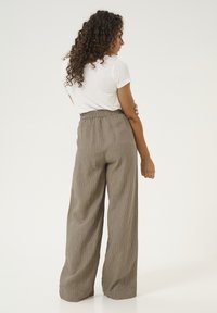 Lightweight, high-waisted, wide-leg trousers in soft, textured fabric with a brown pinstripe pattern and an elastic waistband.