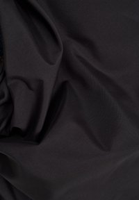 Tissu noir avec de légères rides et plis, montrant une texture lisse et des reflets subtils de lumière.