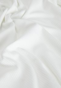 Textured white fabric with subtle vertical stripes, showcasing soft draping and a smooth surface. Ideal for various textile applications.
