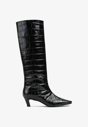 Czarne kozaki do kolan wykonane z błyszczącej skóry tłoczonej w wzór krokodyla, z spiczastym noskiem i niskim, grubym obcasem. Wzór teksturowany w całej powierzchni.