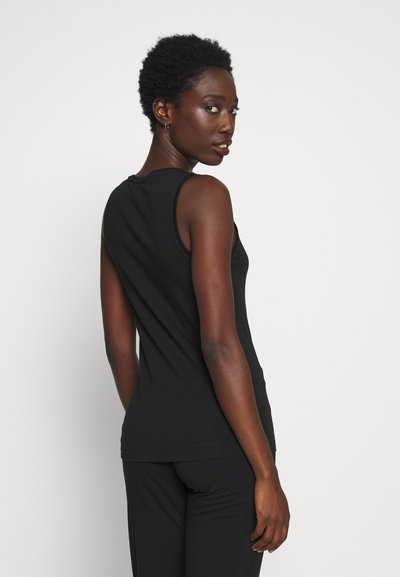 Camiseta sin mangas negra hecha de una tela suave, con un diseño ajustado y una textura lisa. El modelo se ve desde atrás.