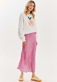 Bavlněná mikina s grafikou "PEACH PLEASE", v kombinaci s růžovou sukní s puntíky a béžovými teniskami. Měkký materiál, uvolněný střih.