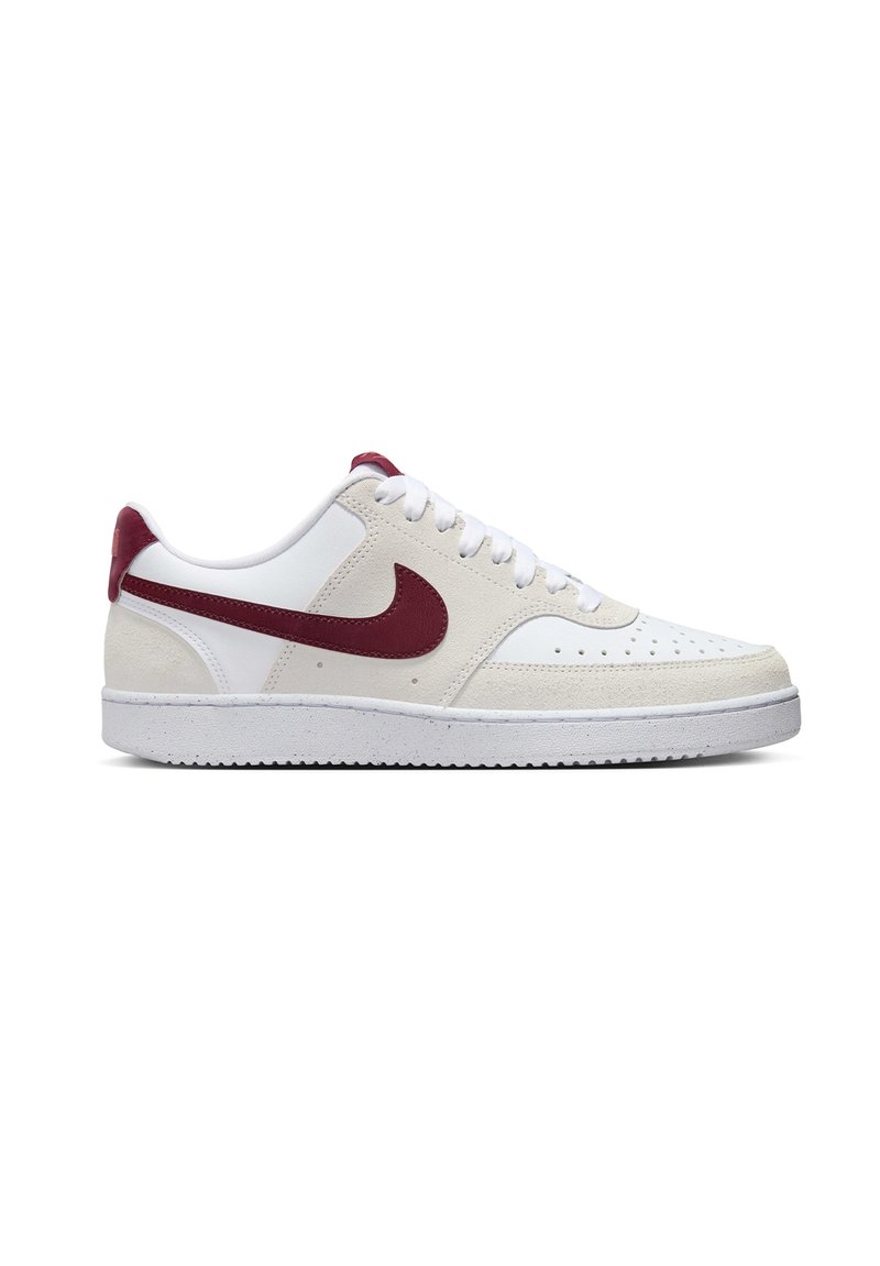 White sneaker with red accents, featuring a textured suede and smooth leather design, white rubber sole, and perforated toe for breathability.