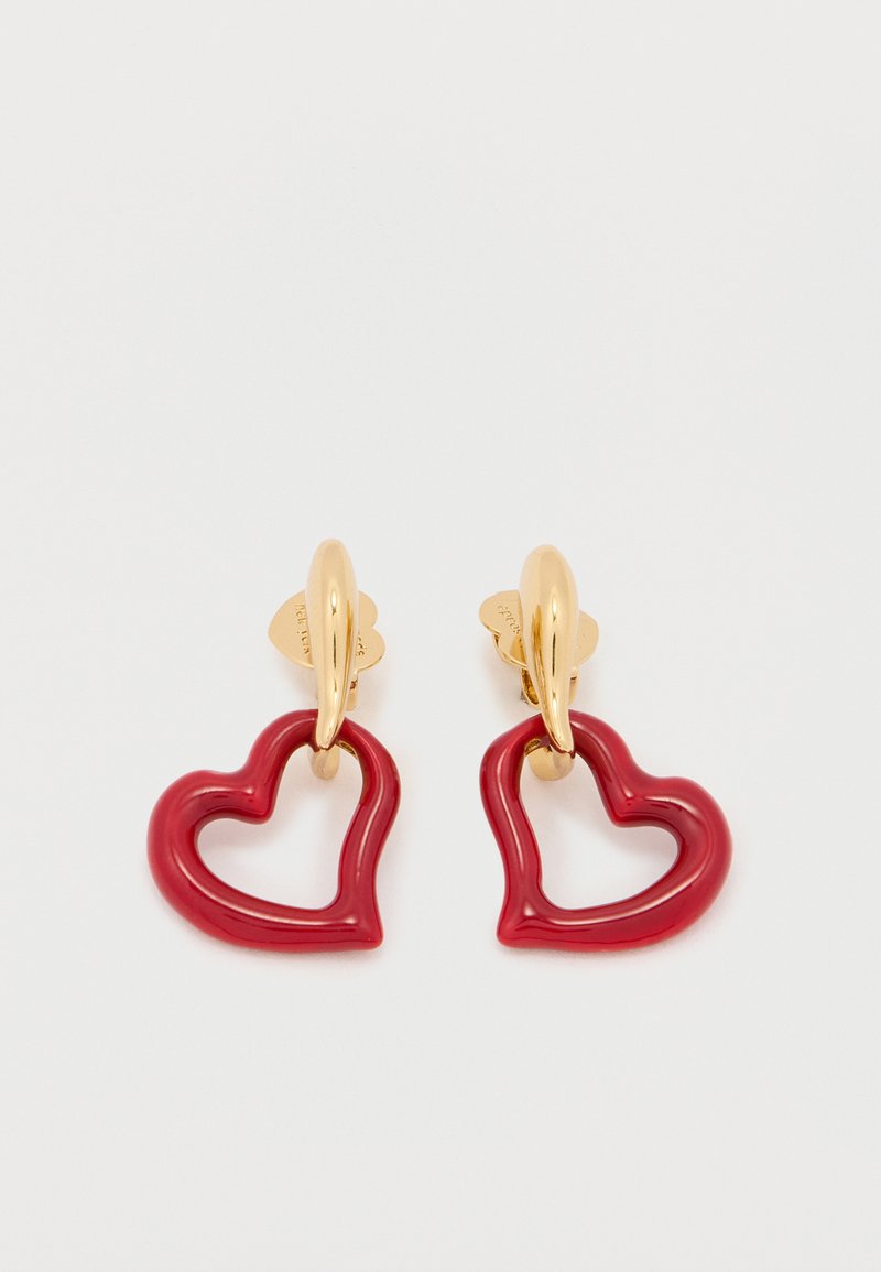 Κόκκινα σκουλαρίκια σε σχήμα καρδιάς με γυαλιστερό φινίρισμα, που διαθέτουν αγκίστρια σε χρυσό τόνο και κοίλο σχέδιο. Ελαφρύ και παιχνιδιάρικο στυλ.