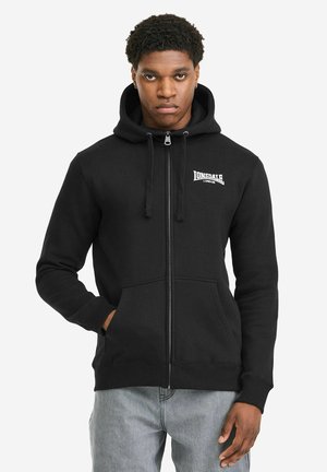 Juodas užtraukiamas džemperis iš minkštos medžiagos, su gobtuvu, reguliuojamu raišteliu, priekinėmis kišenėmis ir baltu logotipu kairėje krūtinės pusėje.