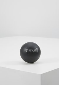 Black massage ball with a smooth texture, featuring a white "casall" logo printed on one side, placed on a minimalist white surface.