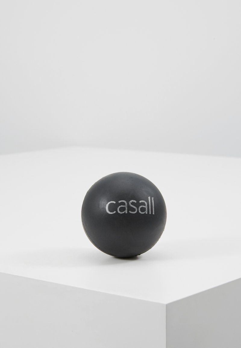 Black massage ball with a smooth texture, featuring a white "casall" logo printed on one side, placed on a minimalist white surface.