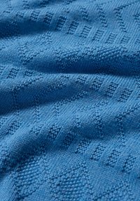 Auda auduma tumši zila krāsa ar struktūru, kas ietver dimanta un horizontālas svītras, radot vizuāli atšķirīgu virsmu.