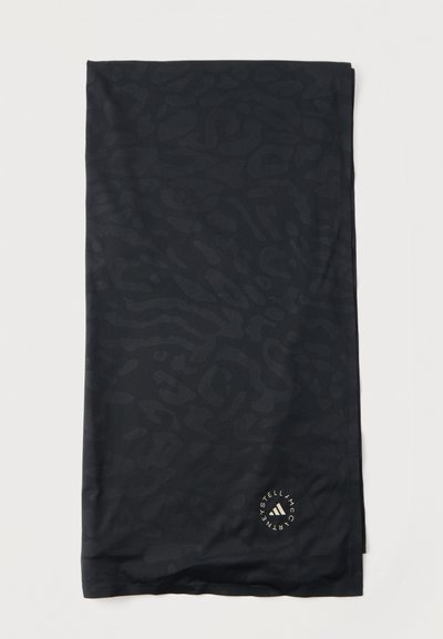 Μαύρο ύφασμα με διακριτικό σκούρο σχέδιο ζωικής εκτύπωσης, διπλωμένο, με μικρό κυκλικό λογότυπο Stella McCartney κοντά σε μία γωνία.