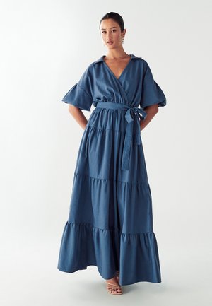 Blue cotton maxi dress with a wrap design, short puff sleeves, tiered ruffles, and a tied waist belt, featuring a smooth texture.