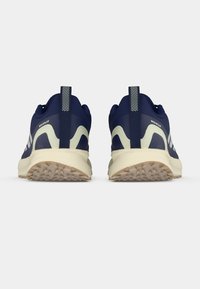 Αθλητικά παπούτσια σε ναυτικό μπλε με υφή στη λαστιχένια σόλα, λευκές ρίγες διακόσμησης και επένδυση στο πίσω μέρος του παπουτσιού. Διαθέτουν ταινία για εύκολη φορεσιά.