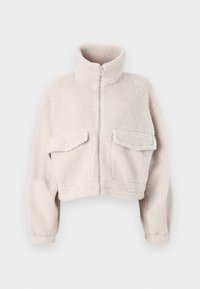 Lyhyt, vaaleanbeige fleece-takki korkealla kauluksella, vetoketjulla edessä ja kahdella etupussitaskulla. Pehmeä rakenne, jossa on ylellinen tuntuma.