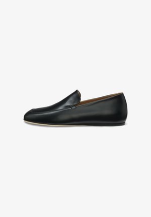 Black leather slip-on loafer with a rounded toe and low, flat sole shown from side profile on white background.
