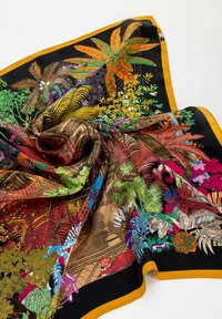 Foulard in seta con motivi botanici e architettonici colorati, che presenta foglie tropicali, fiori e un design intricato su uno sfondo nero con bordo senape.