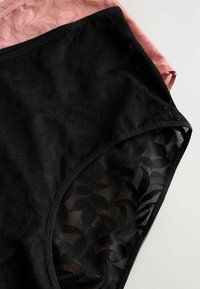 Schwarze und rosa Dessous aus floralem Spitzenstoff, mit weichen Texturen und glatten Kanten, die komplizierte Blattmuster aufweisen.