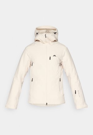 Lichtbeige geïsoleerde jas met een capuchon, voorzien van een ritssluiting aan de voorkant, twee zijzakken met ritssluiting en een logo op de linker borst. Glad textuur.