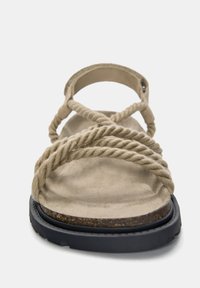 Sandal bej cu bretele din sfoară răsucită, un talpă moale din suede și o talpă texturată din cauciuc negru, văzută din față.