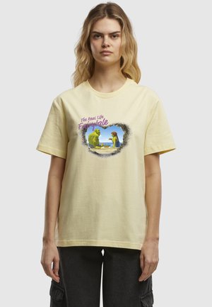 Gul bomulds t-shirt med et grafisk print af en grøn karakter og en person, med teksten "Det ægte livs eventyr" ovenfor.