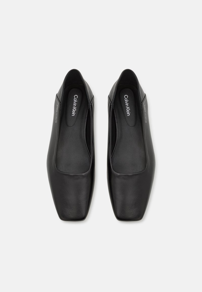Ballerines en cuir noir avec un design à orteil carré, présentant une texture lisse et un minimum de marquage sur la semelle intérieure. Aucune quincaillerie ou accent visible.
