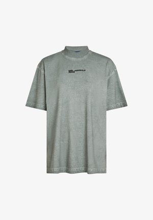 Pelēks īsām piedurknēm T-krekls ar augstu apkakli un melno logo "KARL LAGERFELD JEANS". Izceļas ar strukturētu, mīkstu audumu un taisnu piegriezumu.