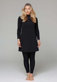 Zwarte lange mouw tuniek met een hoge halslijn, gecombineerd met zwarte legging. Gemaakt van een glad materiaal, met een eenvoudig, gestroomlijnd ontwerp.