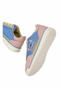 Baskets bleues et roses avec des accents beiges, ornées d'un visage de Stitch en dessin animé et d'un logo sur le côté, avec des semelles texturées blanches et des lacets.