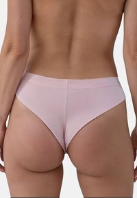 Perizoma leggero rosa con una texture di tessuto liscia, una fascia minimale e un taglio alto, che mette in mostra un design semplice e pulito.