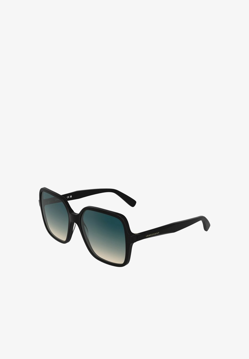 Lunettes de soleil noires surdimensionnées avec une forme octogonale, des verres dégradés bleu s’estompant vers du transparent, et de fines branches noires ornées d’accents de logo.