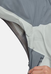 Lichte, tweekleurige jas met grijze en witte panelen. Inclusief ritsen en een ademend interieur met gaasvoering. Textuurstof.