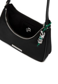 Melnā plecu soma ar sudraba rāvējslēdzēju, sudraba logotipa plāksni un dekoratīvu atslēgu ķēdīti, daļēji atvērta, lai parādītu melno iekšpusi.