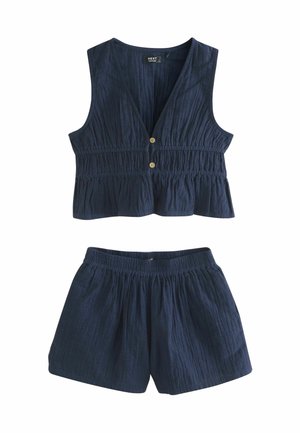 Completo blu navy a due pezzi composto da un top senza maniche con vita arricciata e bottoni in legno, abbinato a pantaloni corti elasticizzati coordinati.
