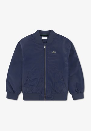 Marineblauw bomberjack gemaakt van glad textiel met geribbelde manchetten en hals, voorzien van een ritssluiting aan de voorkant en een klein groen logo op de borst.