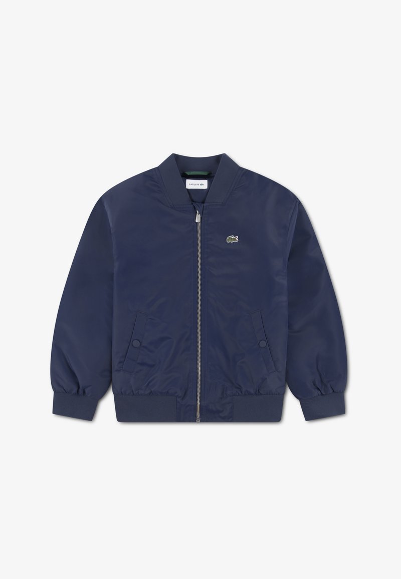 Blouson aviateur bleu marine en textile lisse avec poignets et col côtelés, doté d'une fermeture éclair à l'avant et d'un petit logo vert sur la poitrine.