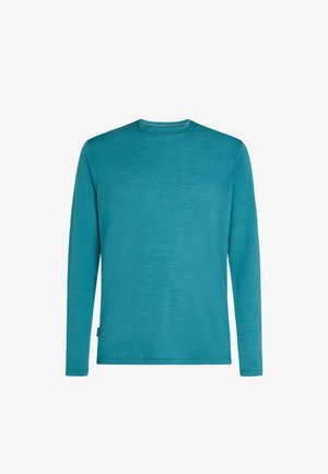 Long-sleeve shirt in teal, made from textured fabric. Features a round neckline and a subtle logo tag on the lower side.