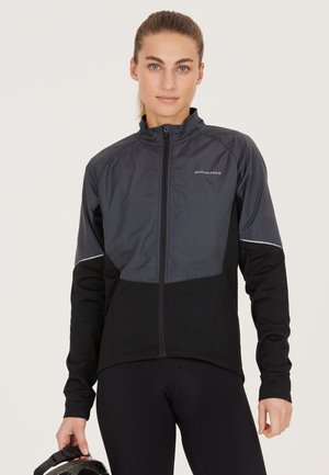 Black and gray cycling jacket featuring a zip front, high collar, and reflective accents. Made from a breathable, textured fabric.