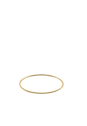 Thin gold bangle with a smooth, shiny surface resting on a white background.